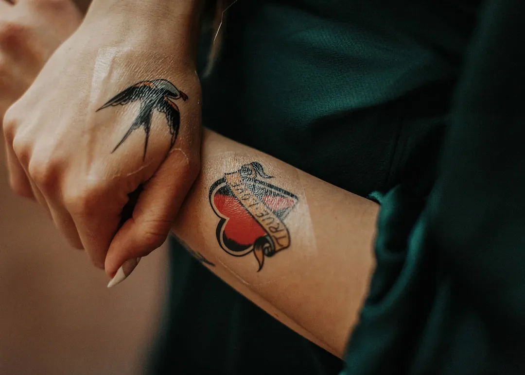 Two tattooed wrists held side by side.