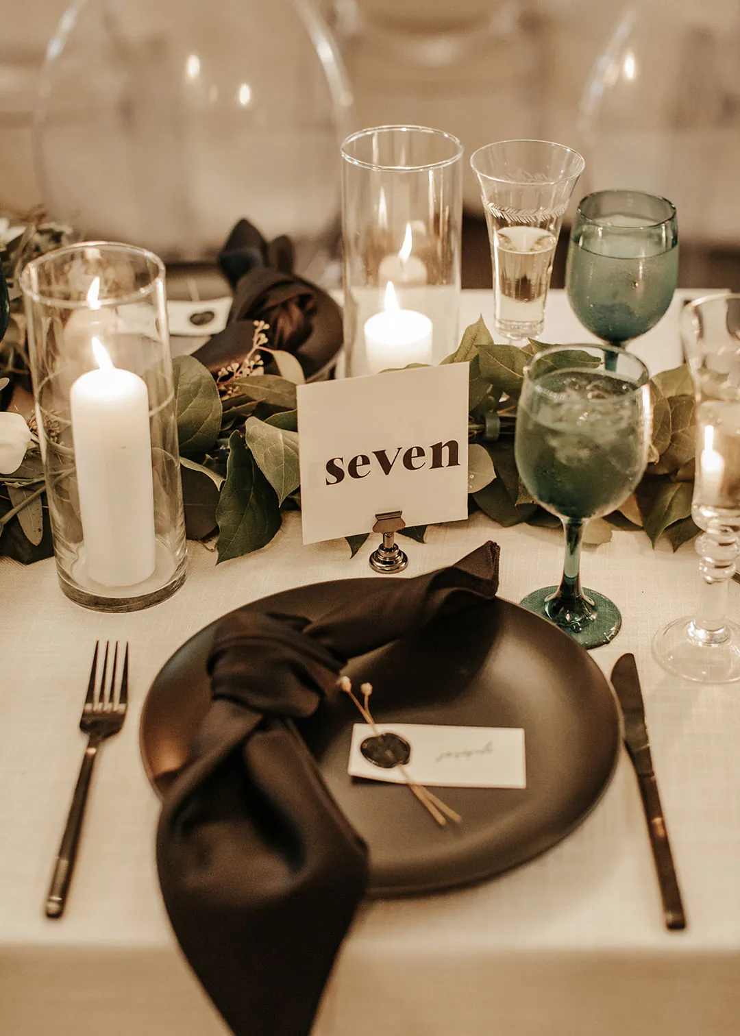 Table number seven beside dark napkins and glassware.