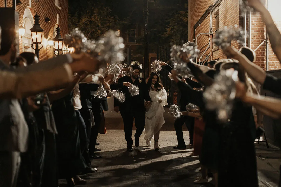 Guests surround newlyweds during a nighttime sendoff.