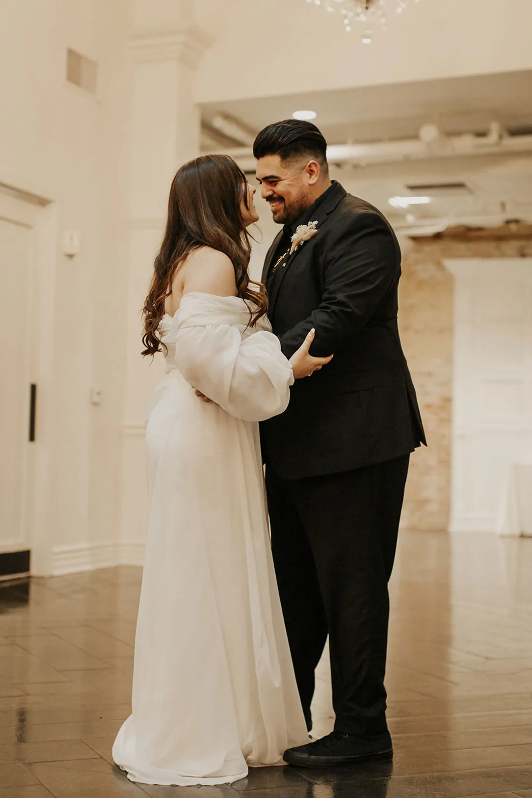 Couple stand together on the reception floor.