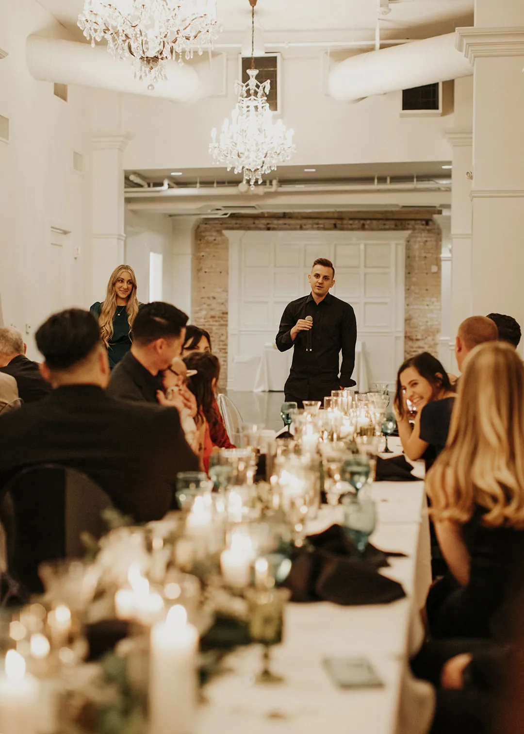 Guest gives a speech beside long reception tables.