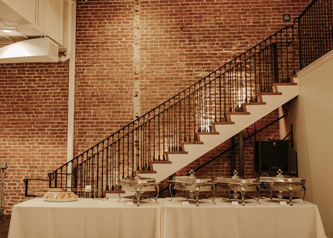 Reception buffet beneath an indoor staircase.