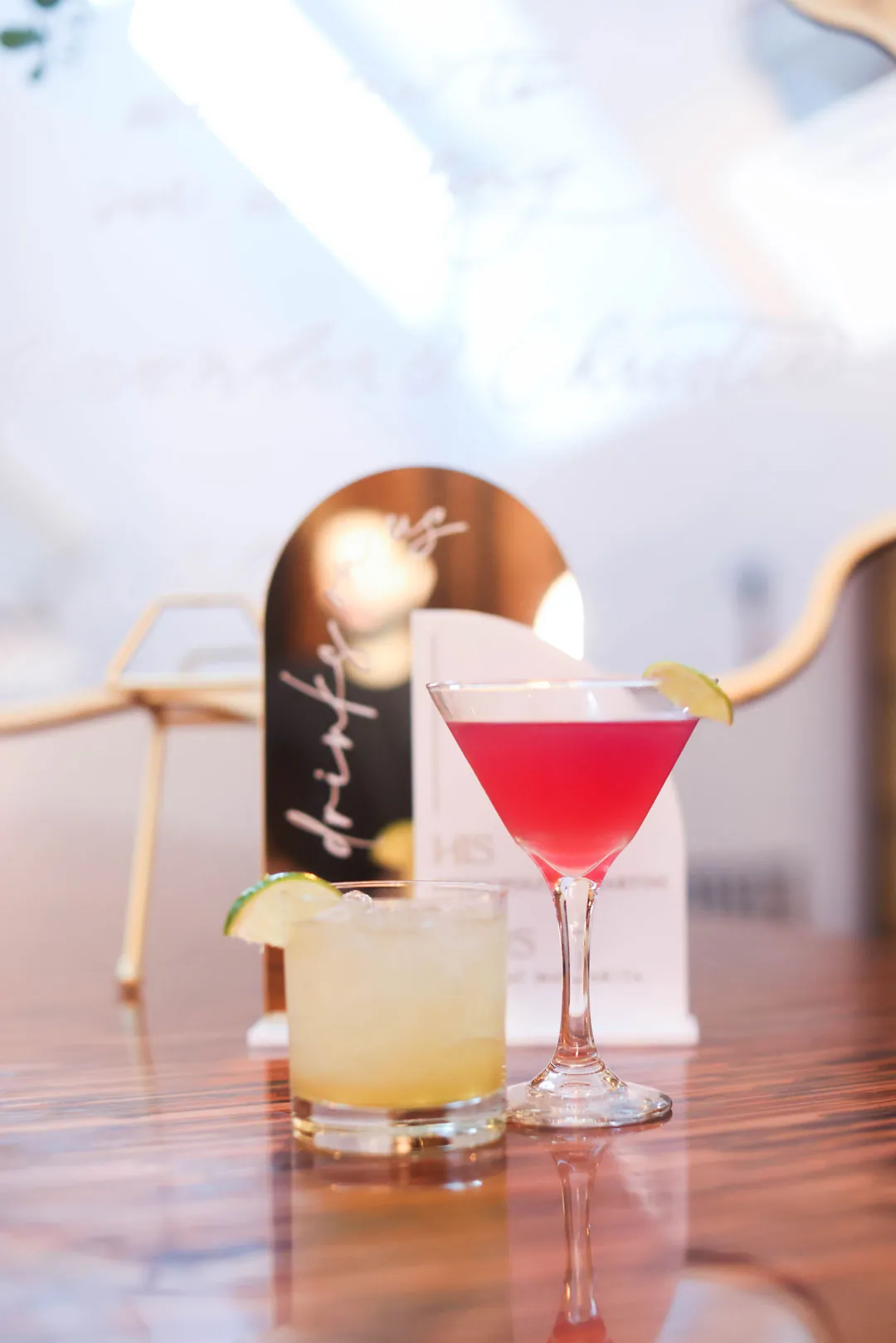 Two signature cocktails on a wooden bar