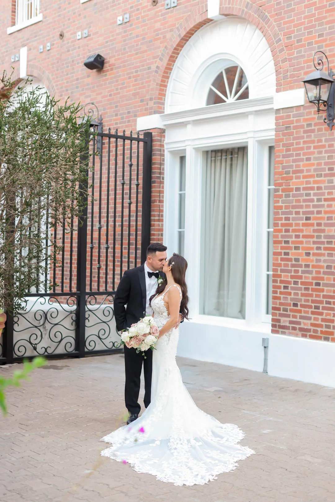 Newlyweds posing outside the arched venue entrance