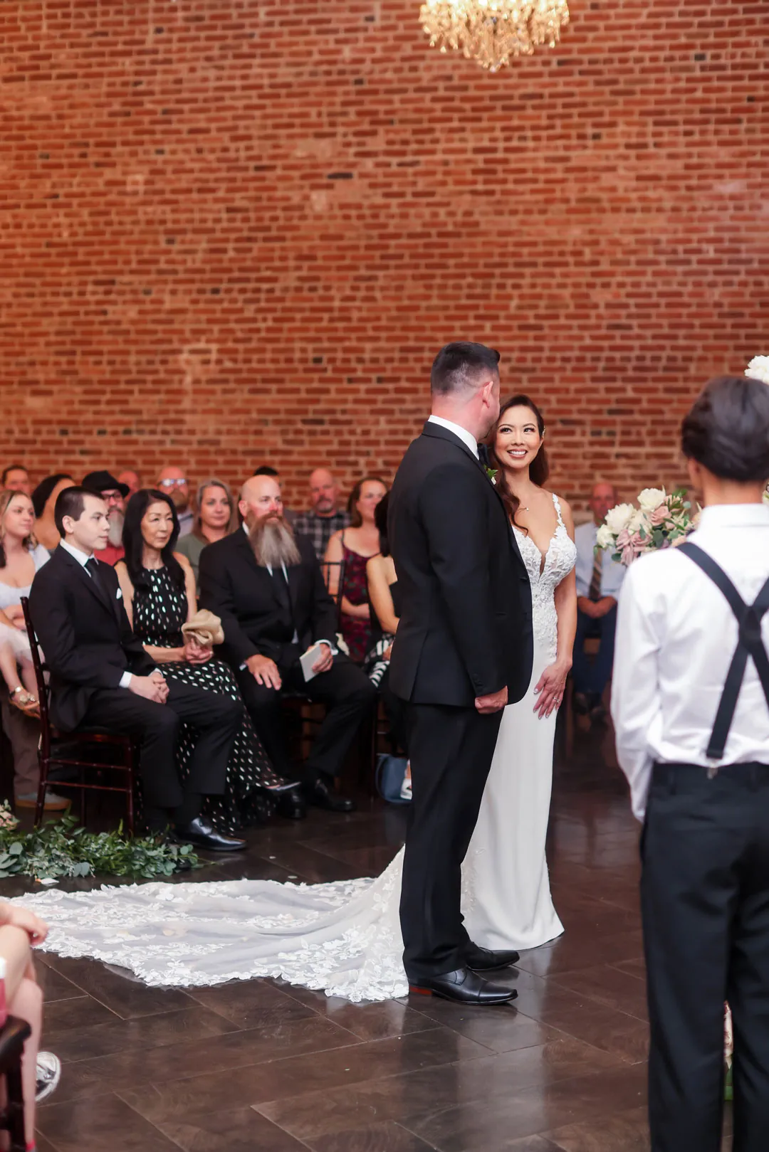 Couple exchanging vows in the brick ballroom