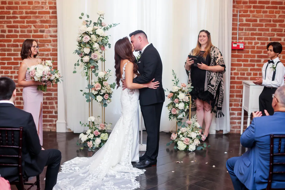 Bride and groom kissing before their guests