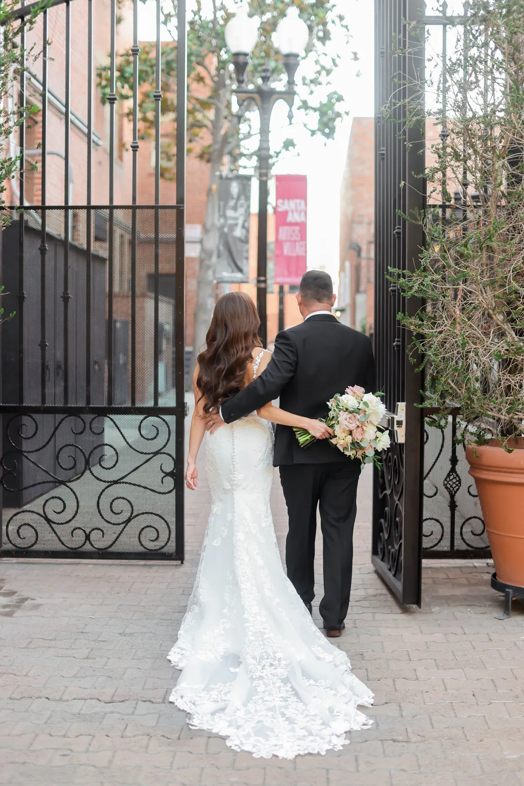 Bride and groom kissing beside a wrought-iron gate