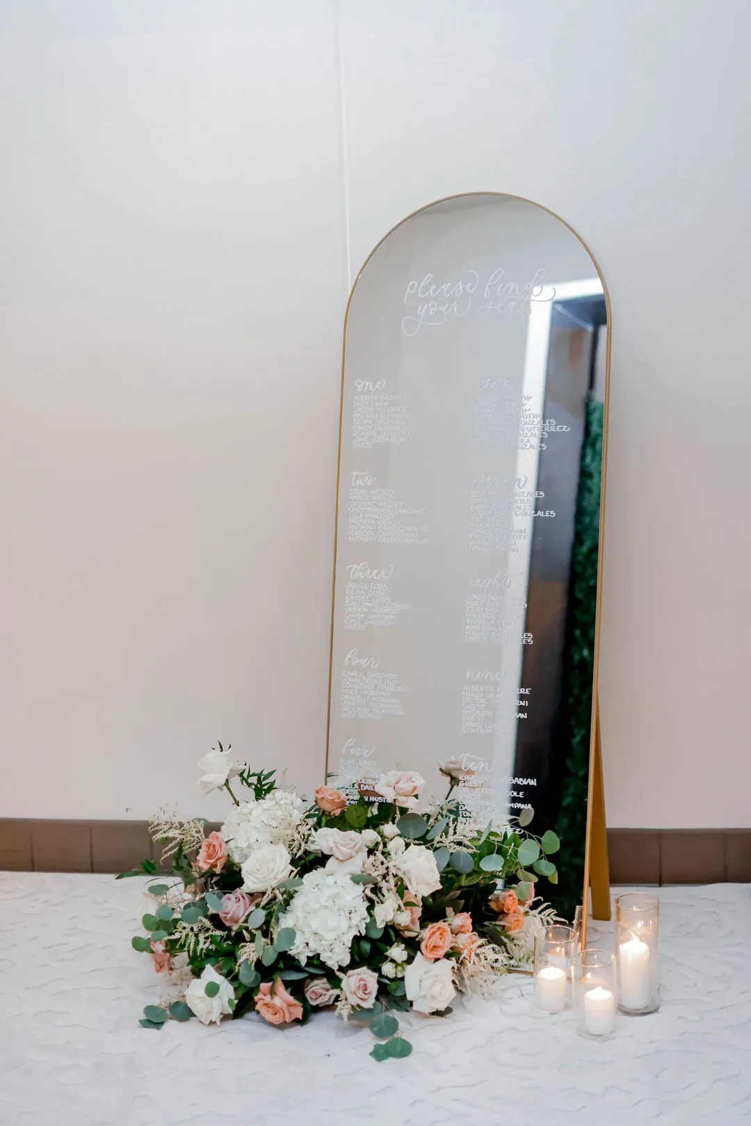 Arched mirror decorated with flowers and candles