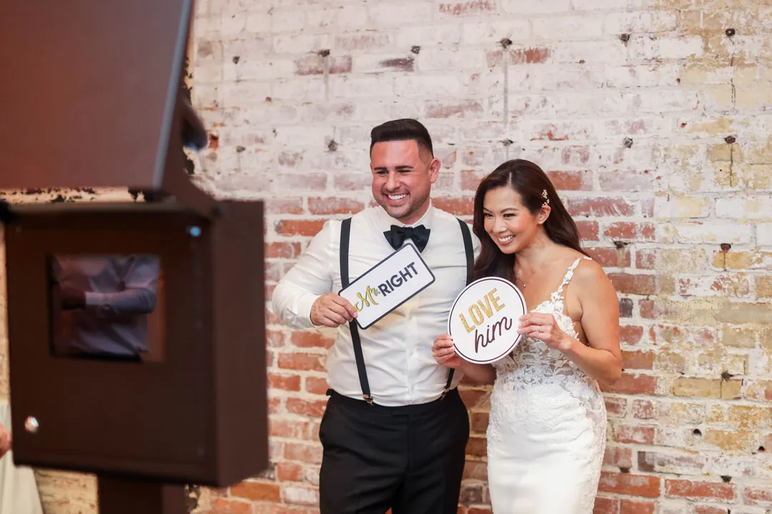 Newlyweds holding photo-booth props