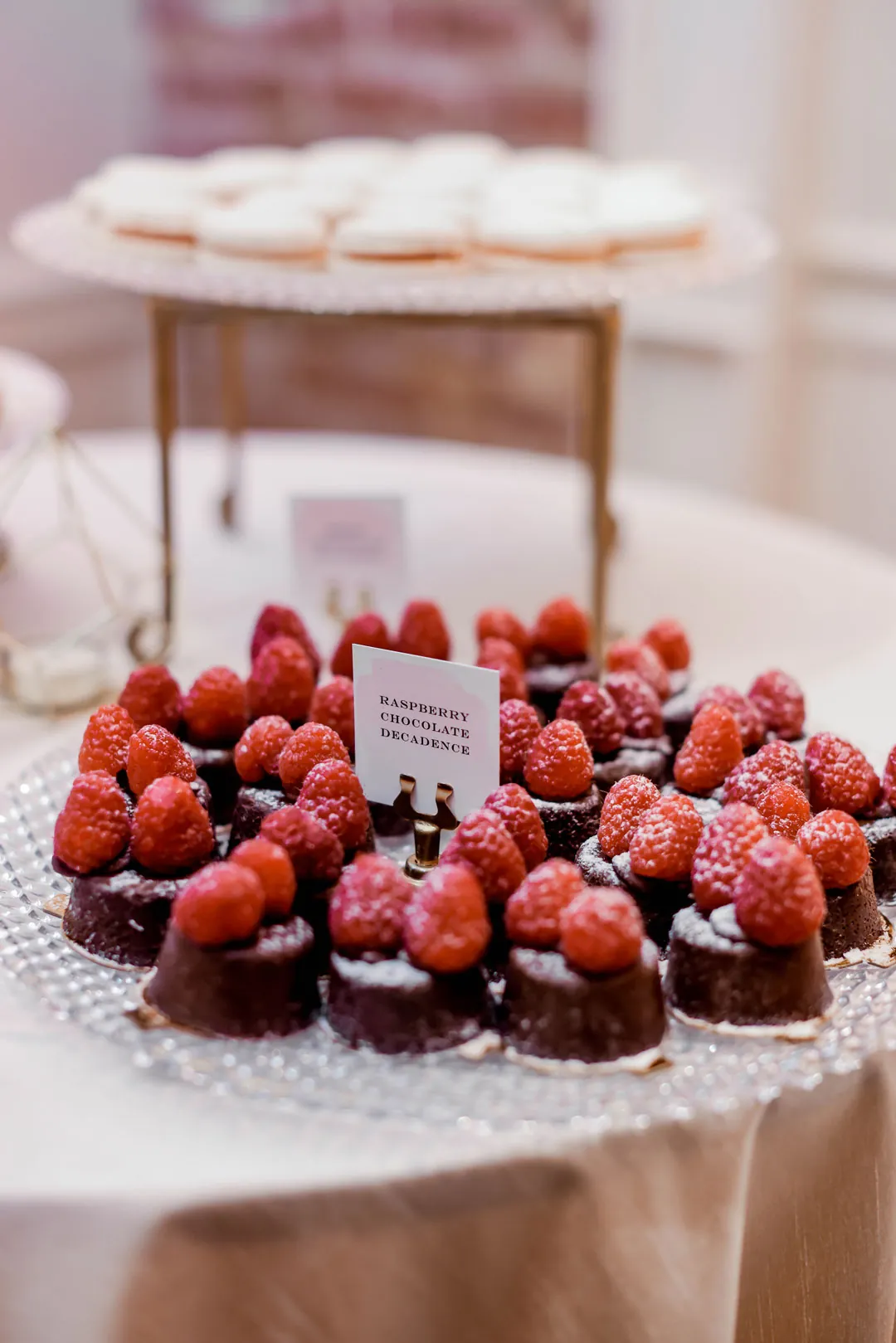 Berry-topped chocolate desserts on a glass stand