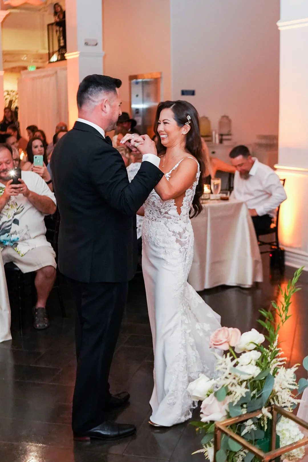 Bride and groom raising drinks at a reception table