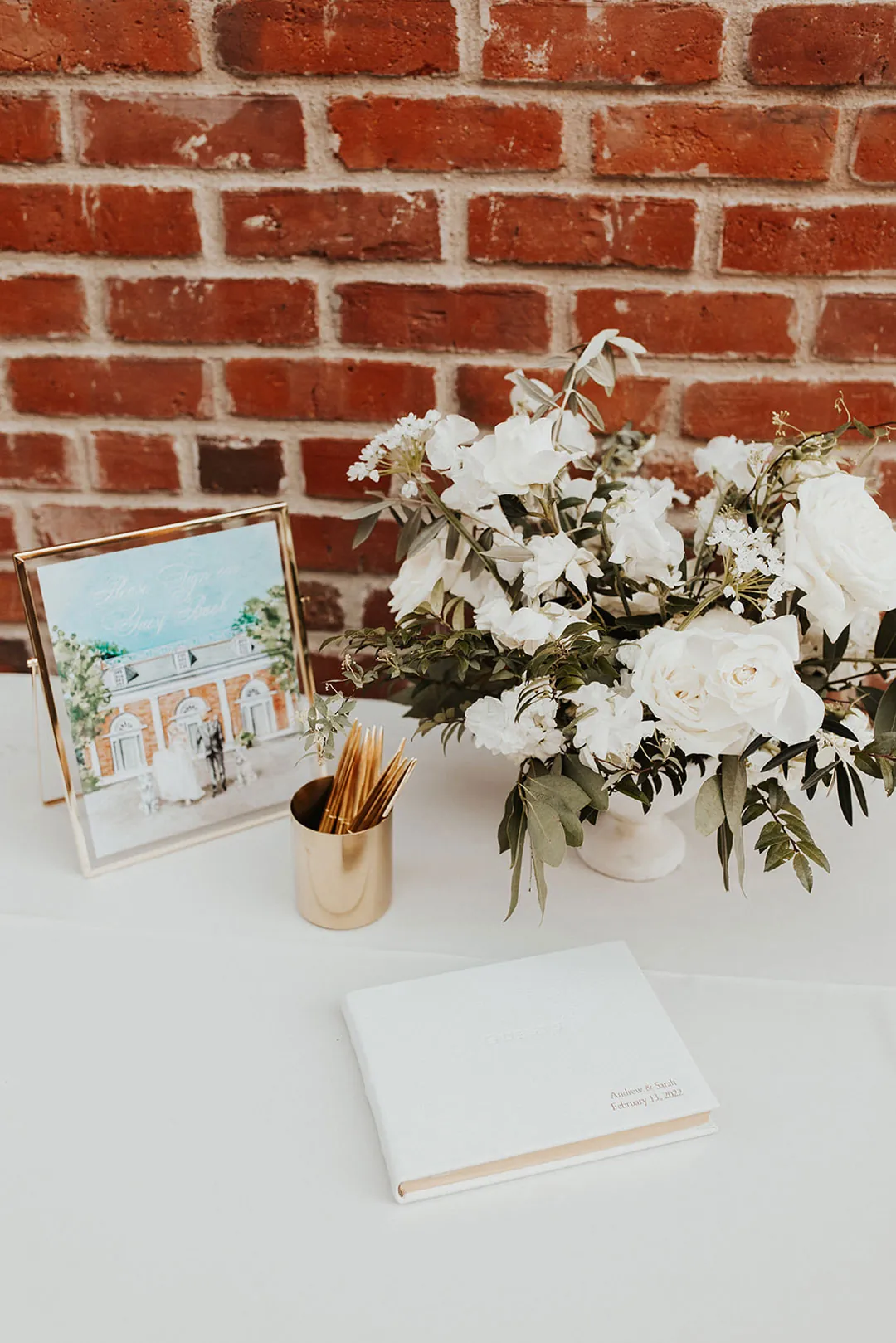 White floral arrangement and guest book on a table