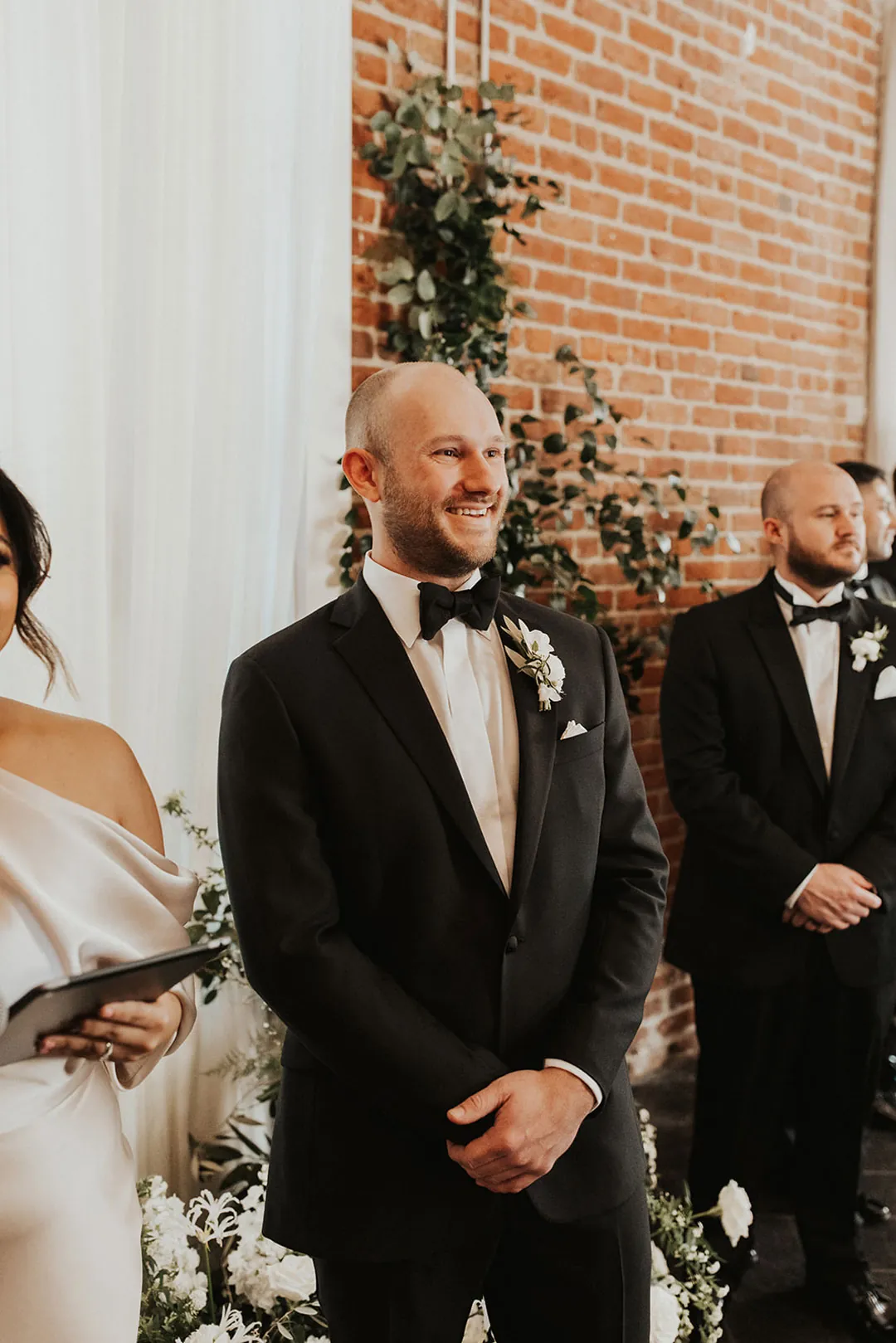 Groom smiling at the front of the wedding ceremony