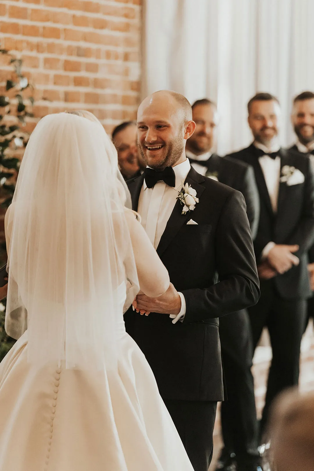 Groom smiling at the bride during the ceremony