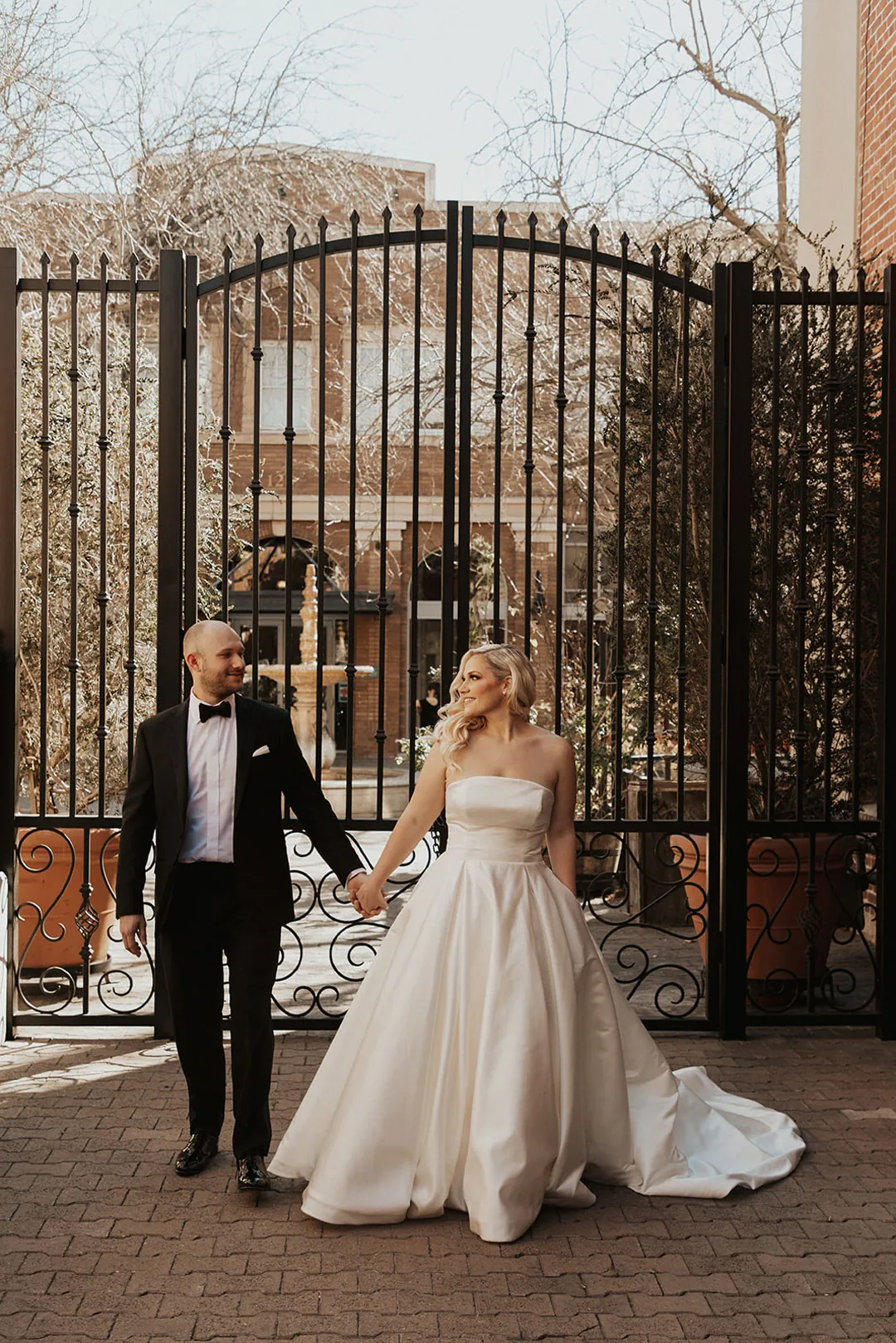 Couple walking together outside an iron gate