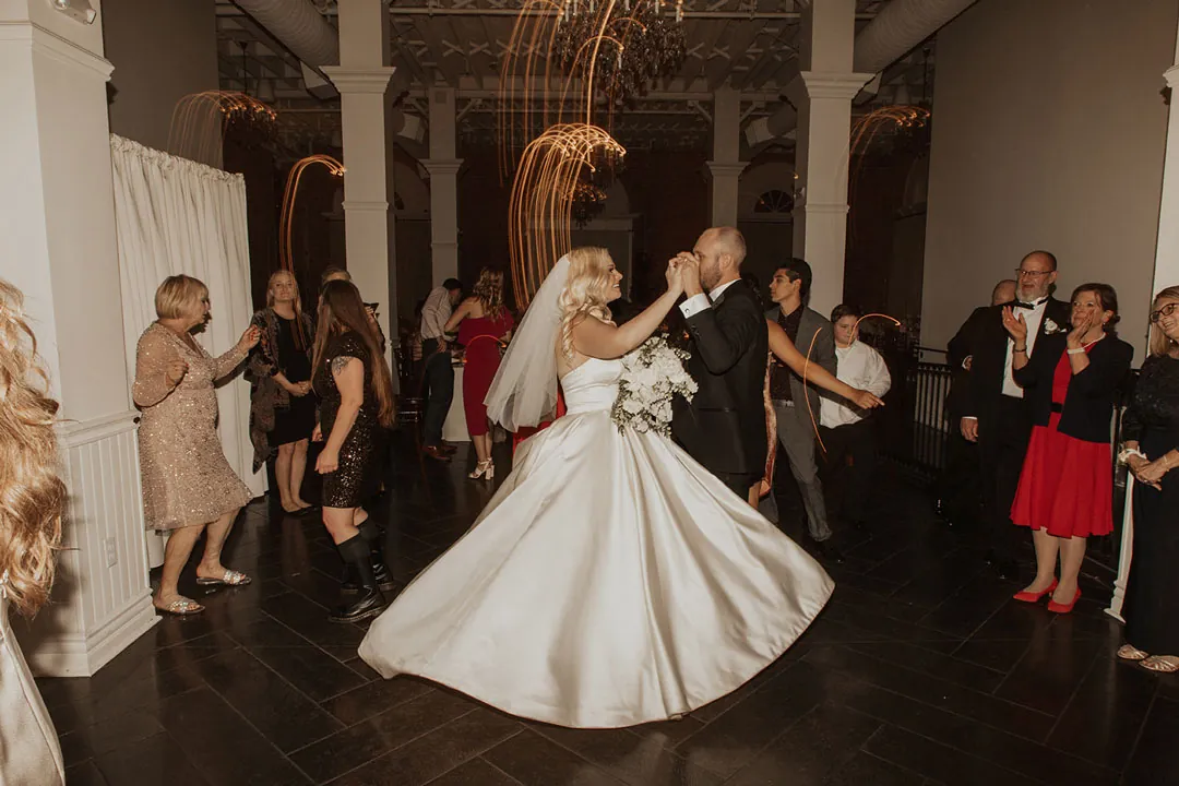 Bride twirling on the dance floor as guests watch