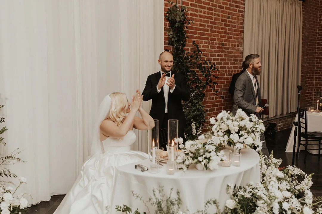 Guest giving a speech beside the seated couple