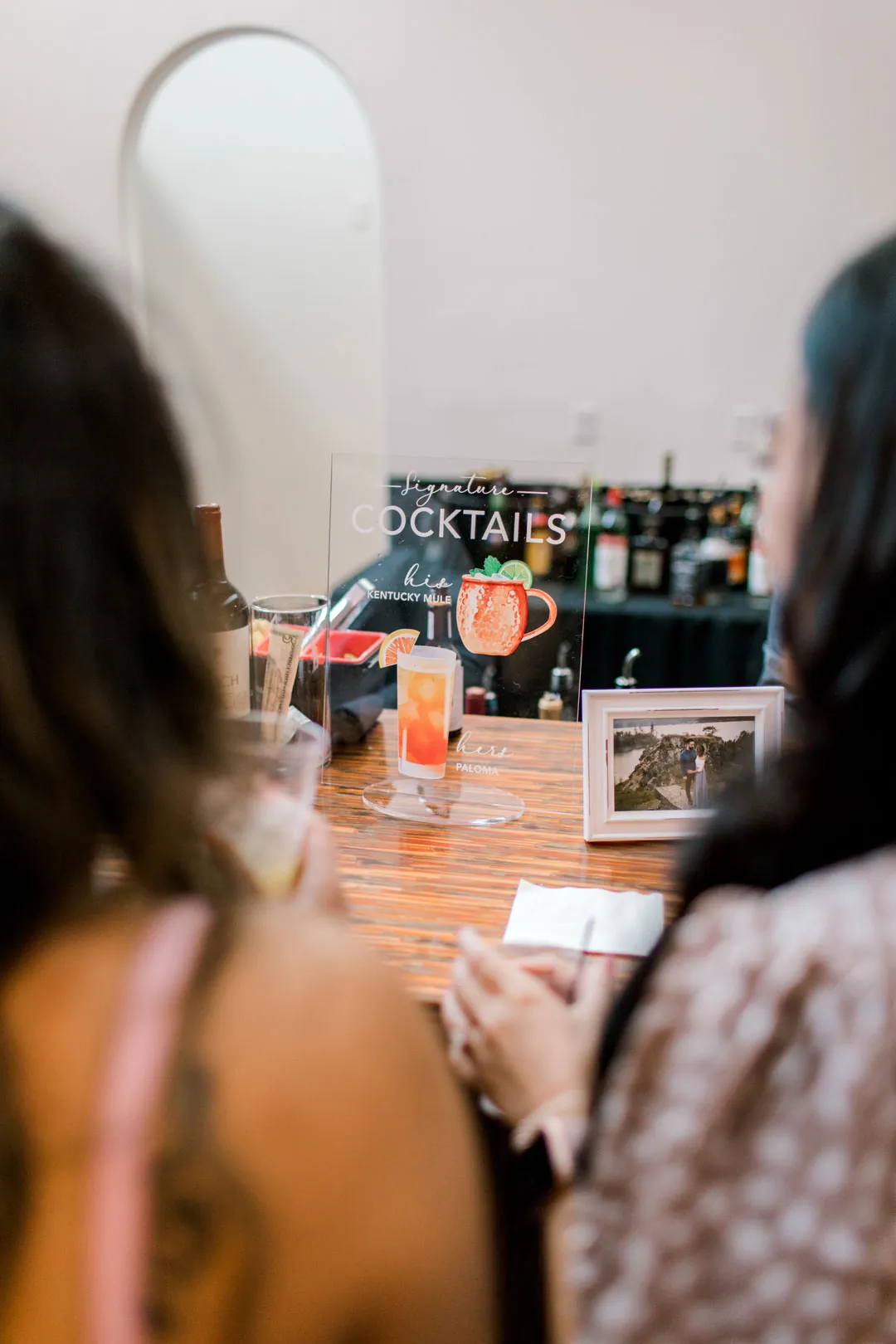 Illustrated signature drinks menu viewed across a bar