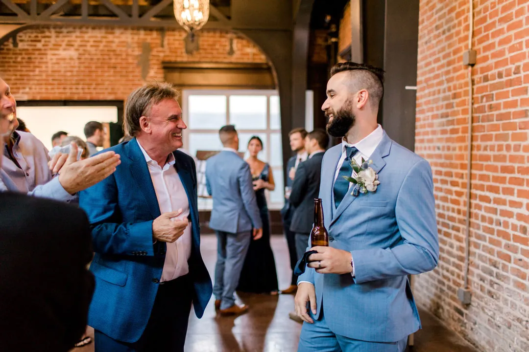 Groom talking with guests during the cocktail reception