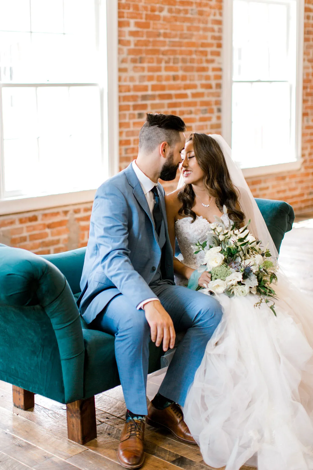 Couple leaning together on a green sofa