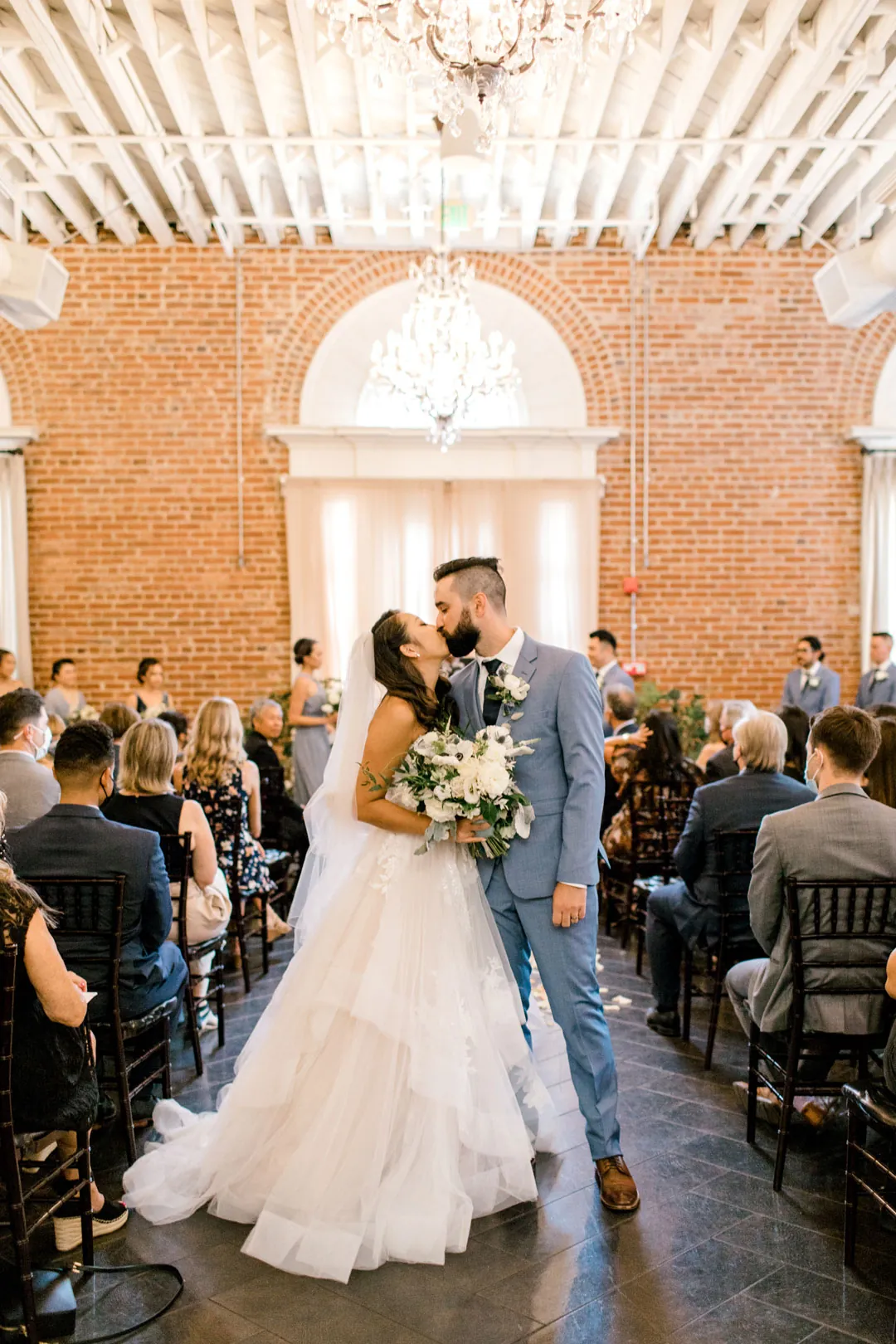 Newlyweds leaving the ceremony between seated guests