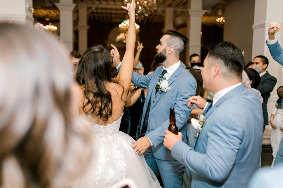 Guests raising glasses as the groom celebrates
