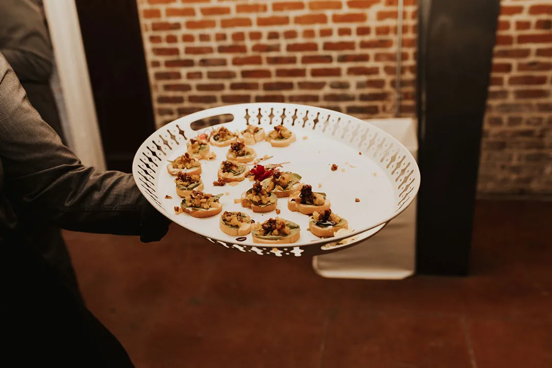 Server carrying a platter of small appetizers