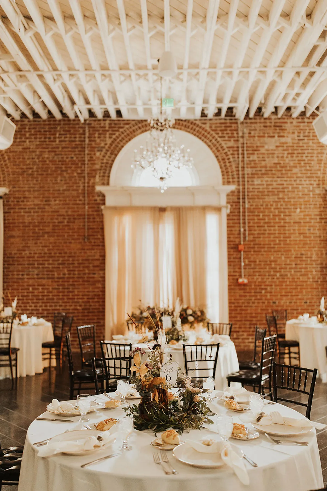 Round reception table beneath an arched window