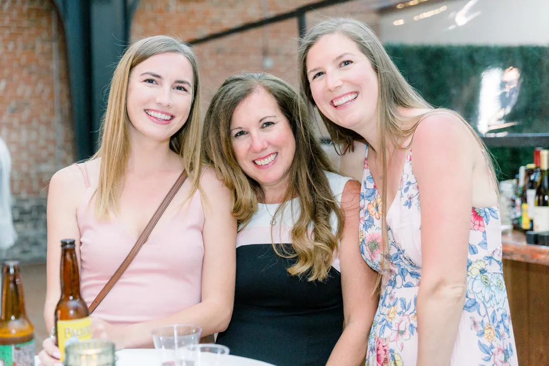 Three guests smiling together during cocktail hour