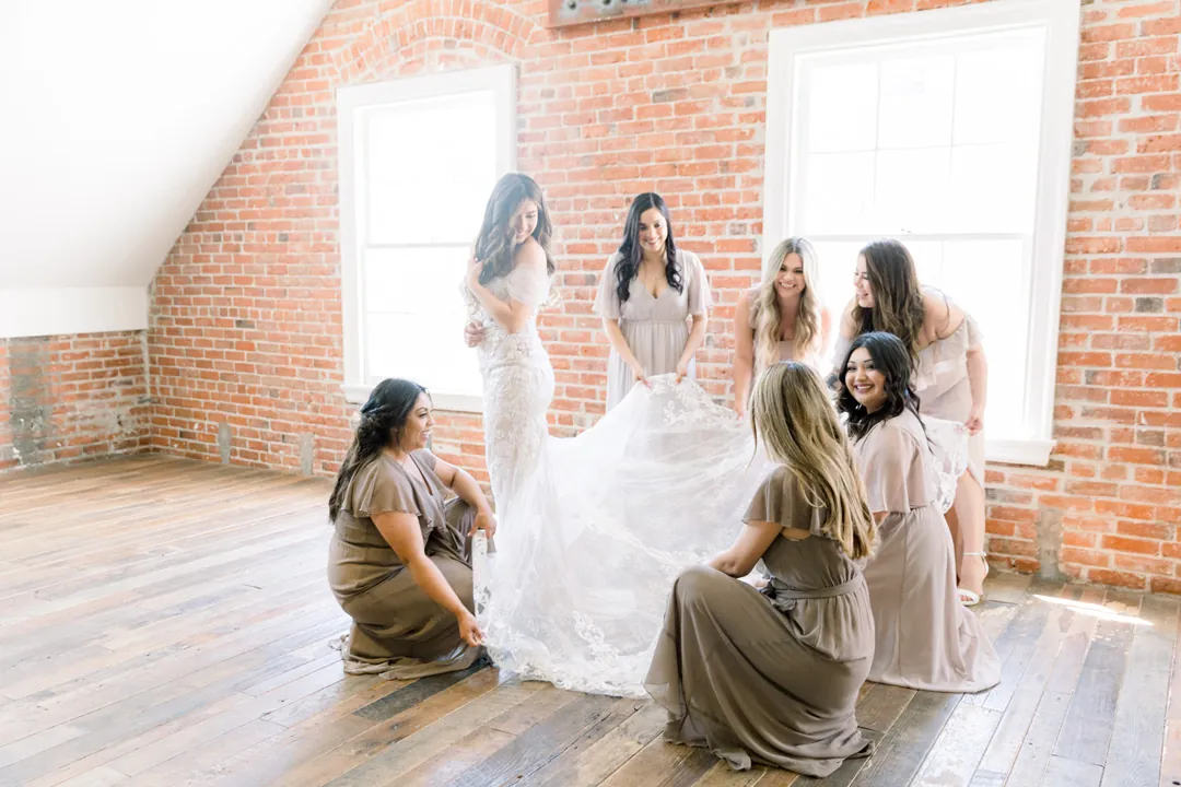 Bride seated among attendants in pale dresses