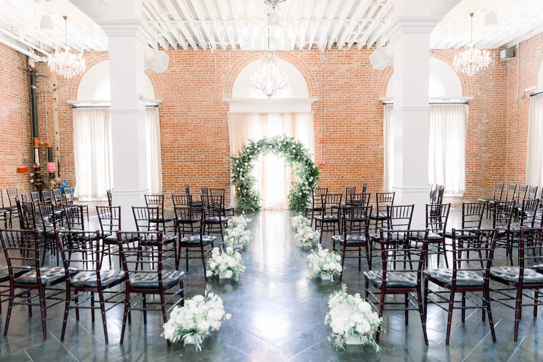 Ceremony chairs facing a circular greenery arch
