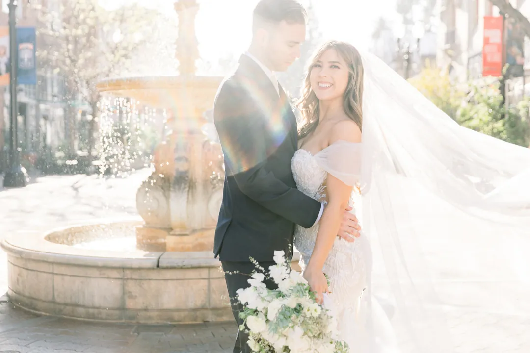 Bride and groom standing together outdoors in soft light