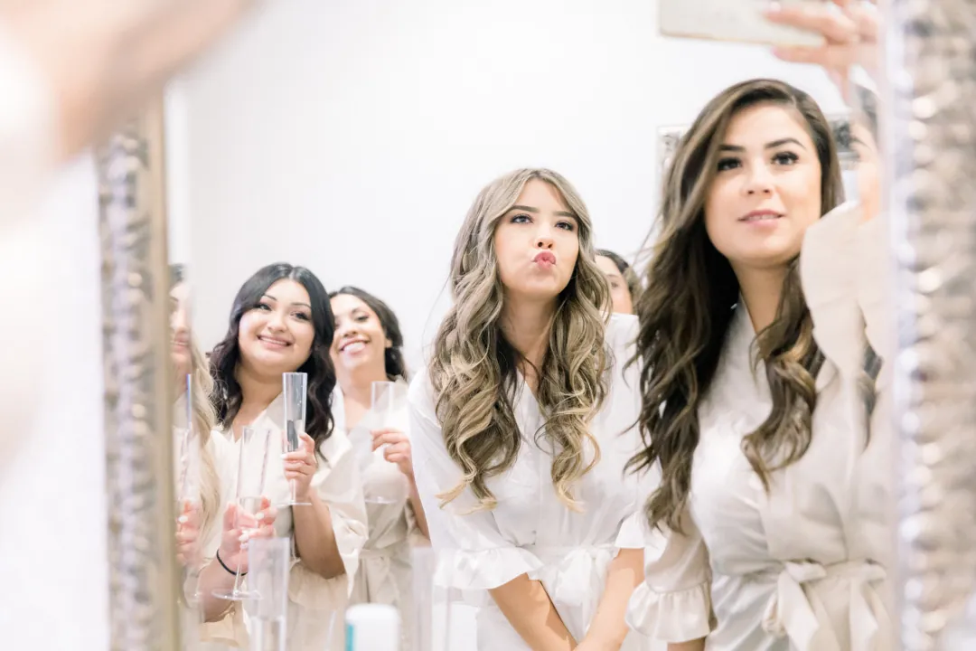 Bride getting ready with attendants in a bright room