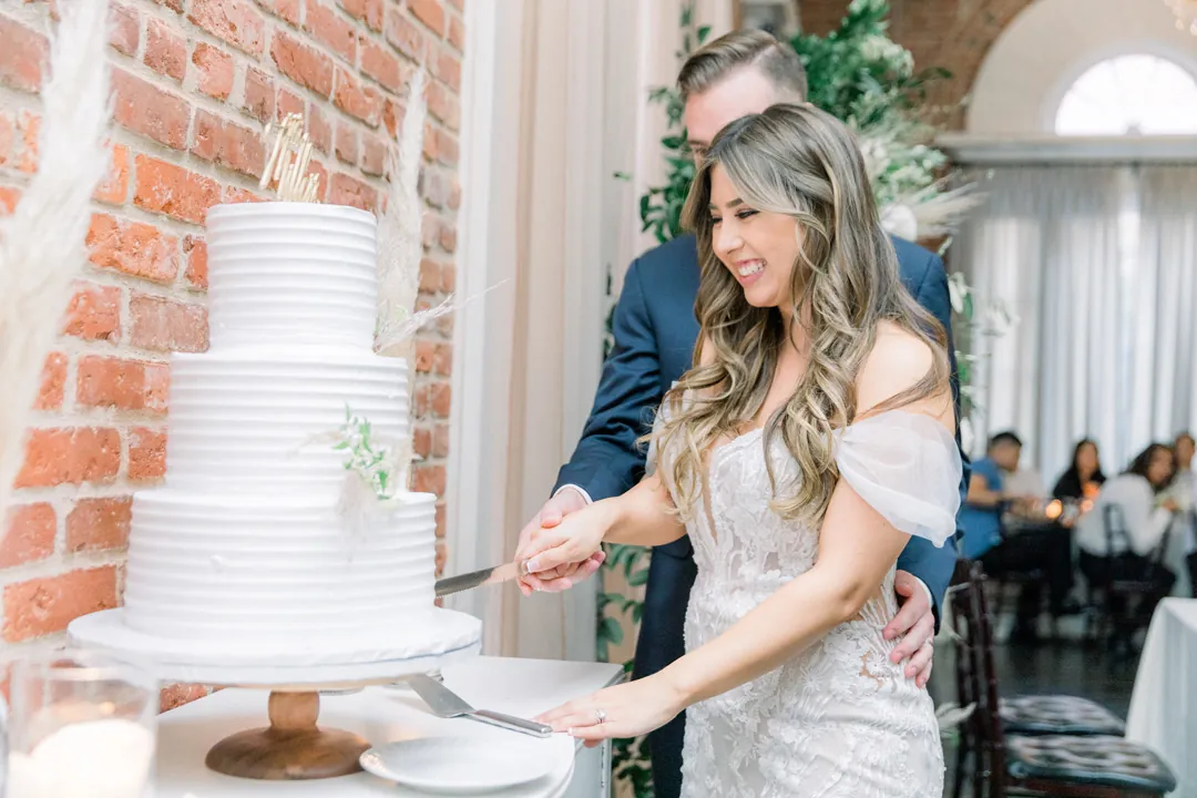 Bride cutting her wedding cake with the groom