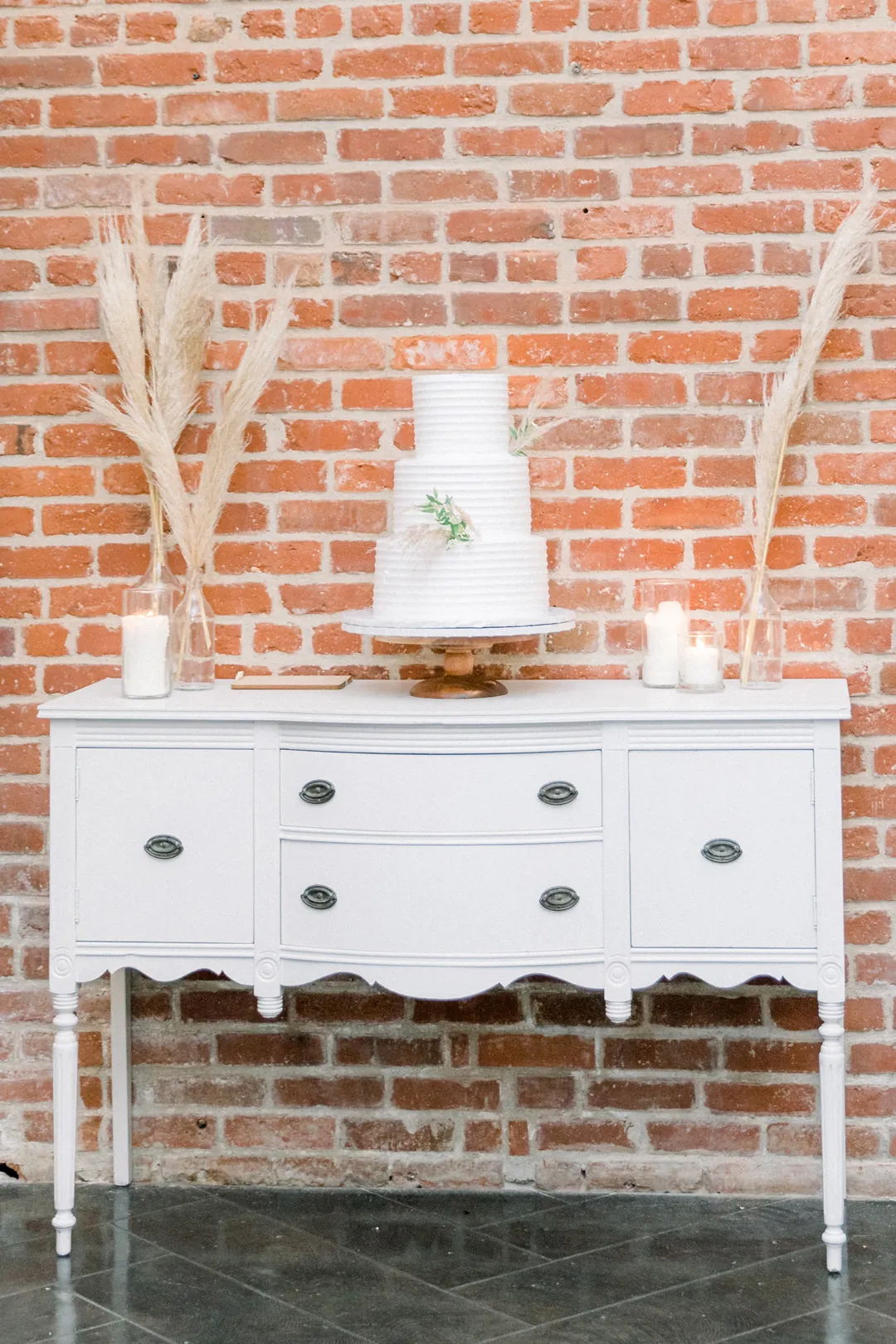 Tiered white cake displayed on a cabinet