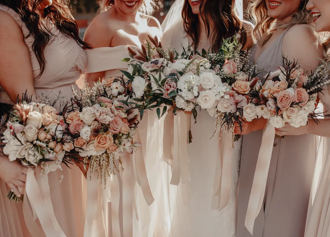 Bridesmaids holding peach and white bouquets