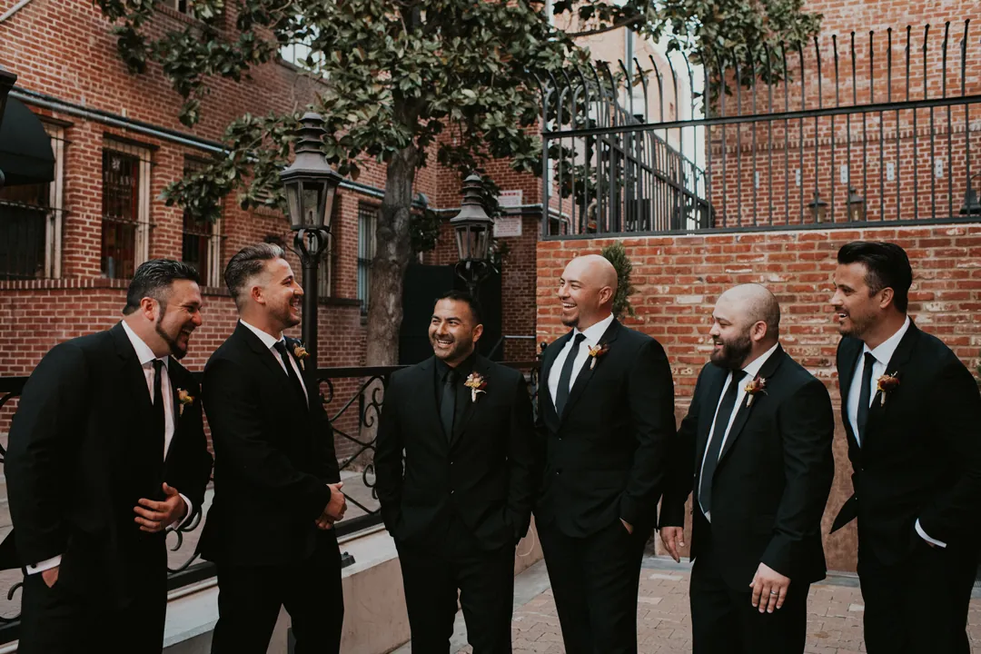 Groom talking with groomsmen outdoors