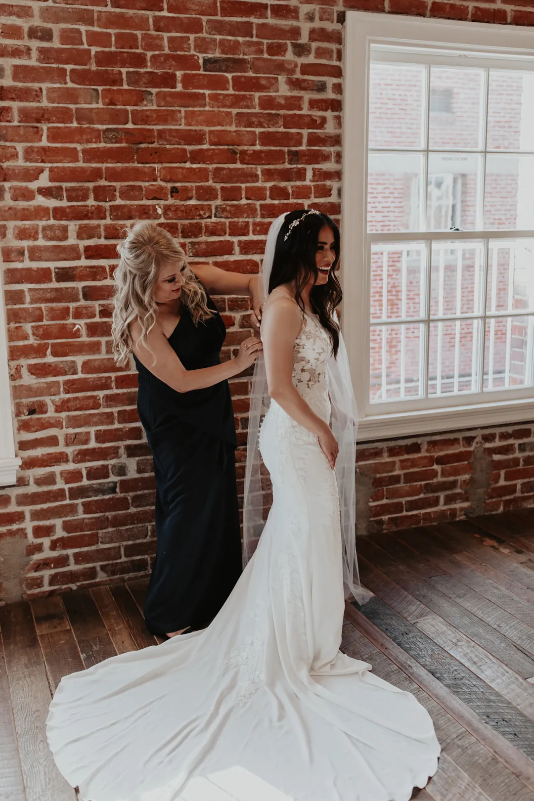 Attendant adjusting the bride's wedding gown