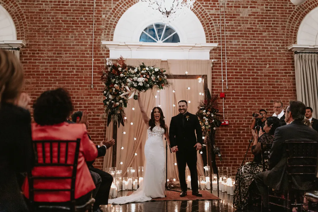 Guests watching the couple at the ceremony backdrop