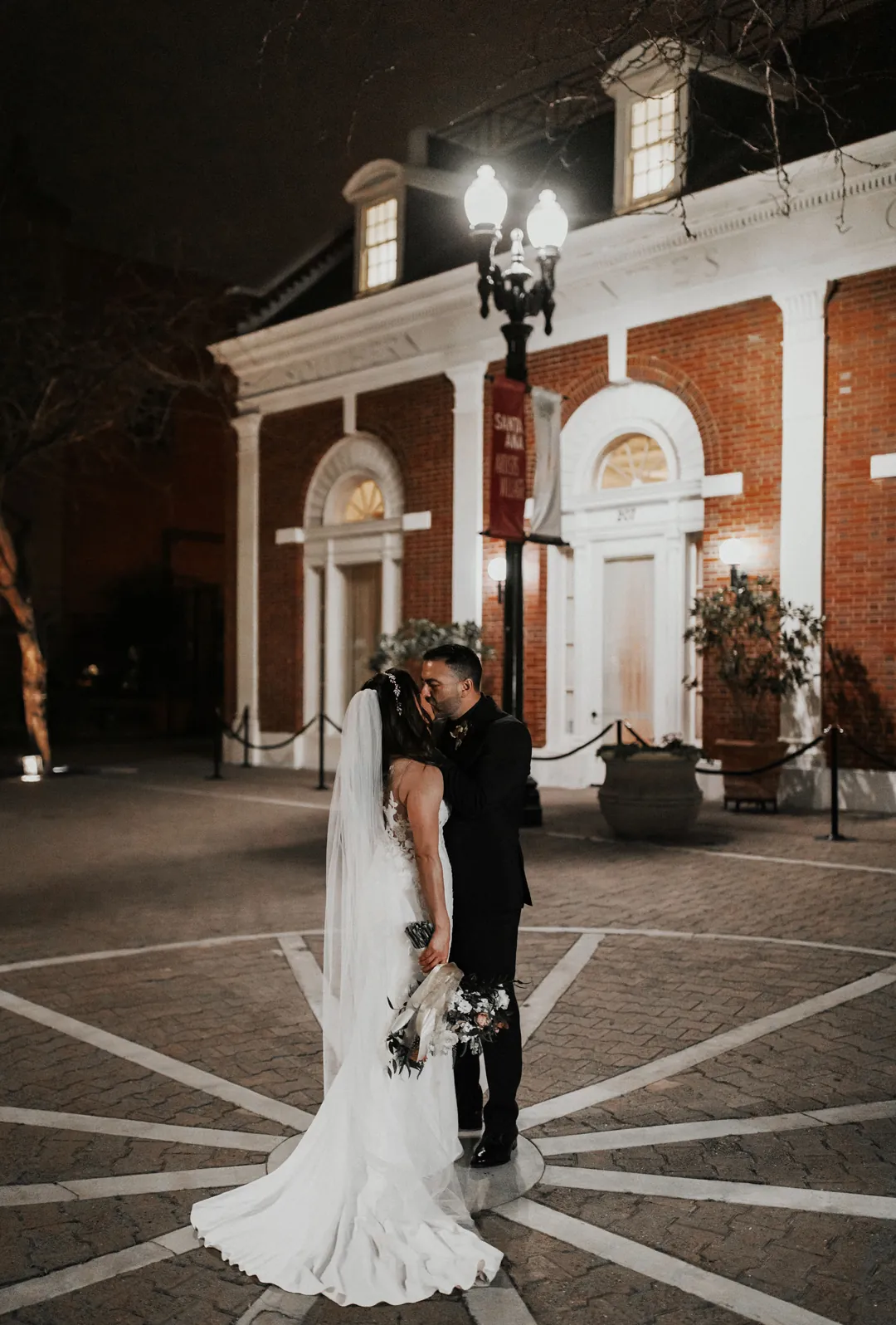 Newlyweds embracing outside the illuminated venue