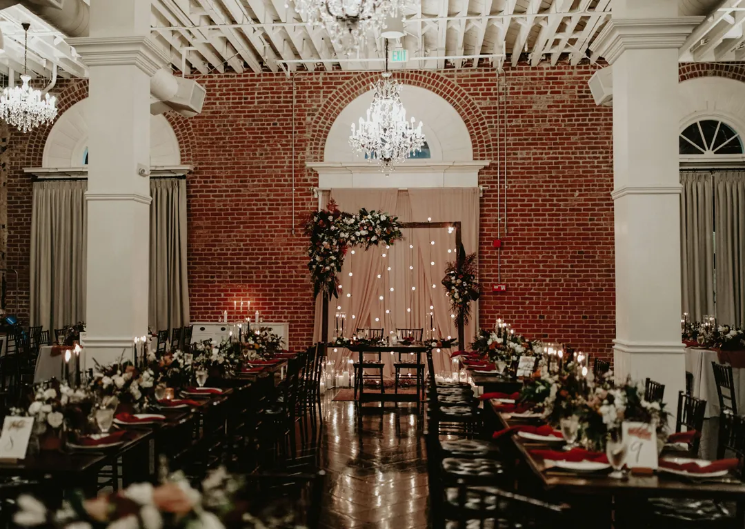 Reception tables and flowers beneath a chandelier
