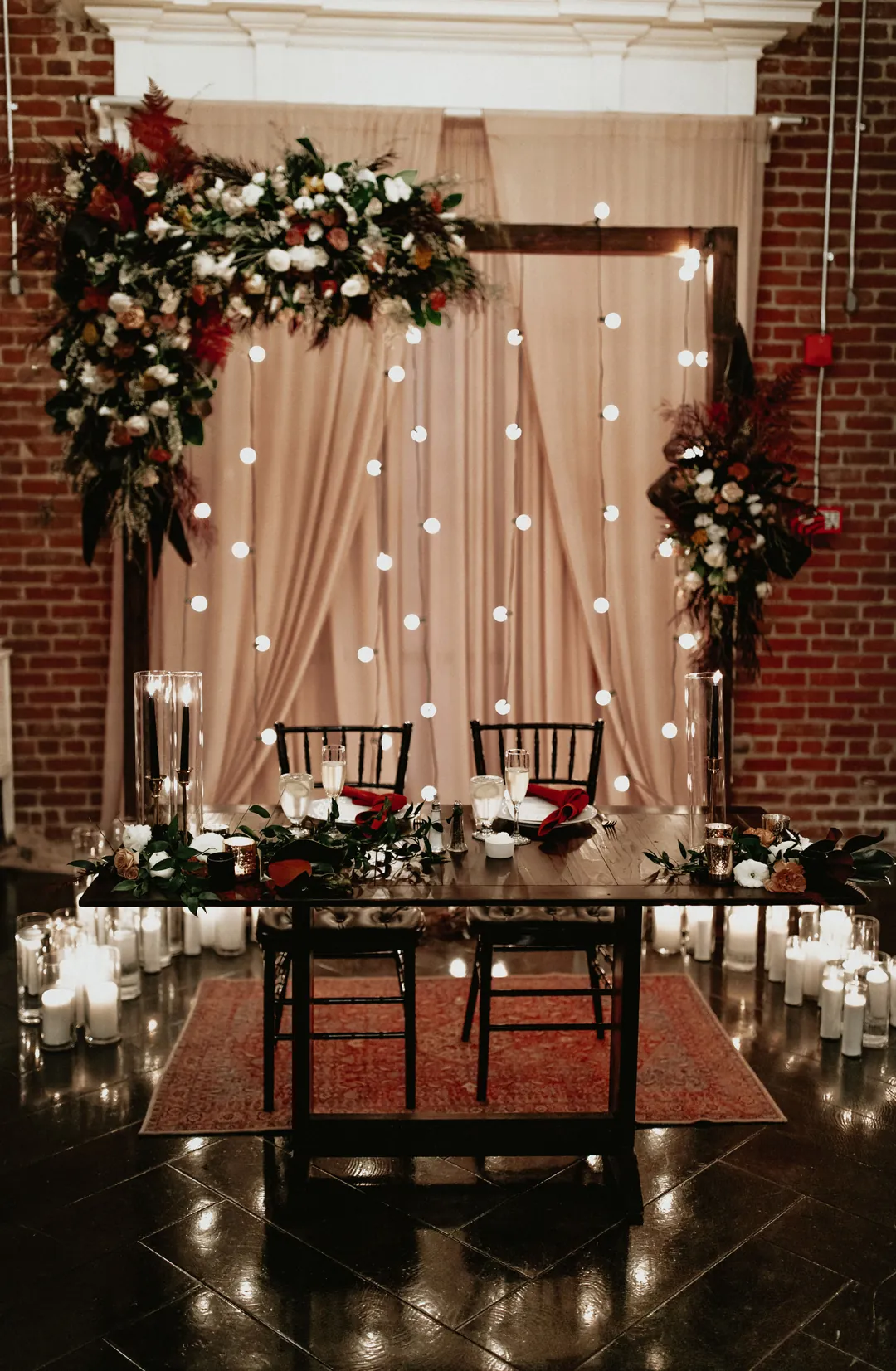 Sweetheart table surrounded by flowers and candles