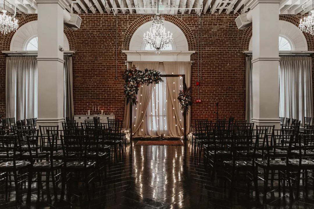 Ballroom ceremony aisle lined with black chairs