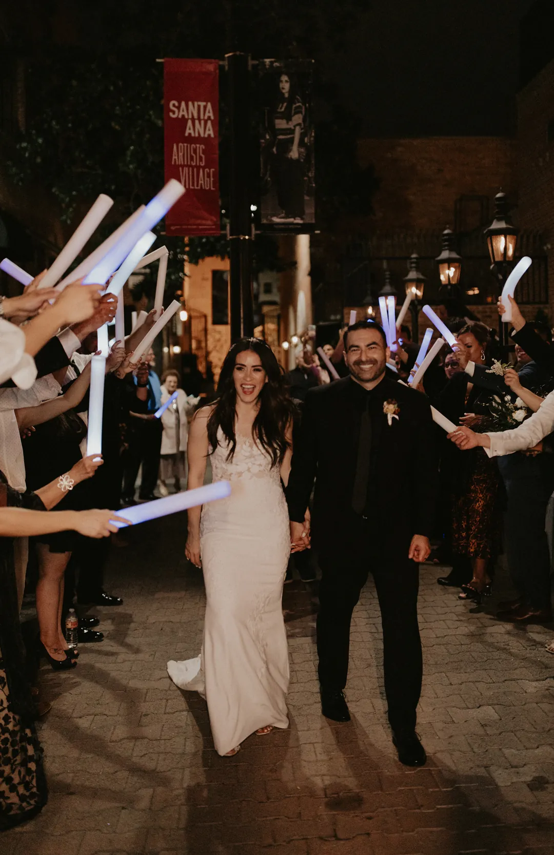 Guests waving glowing sticks around the newlyweds