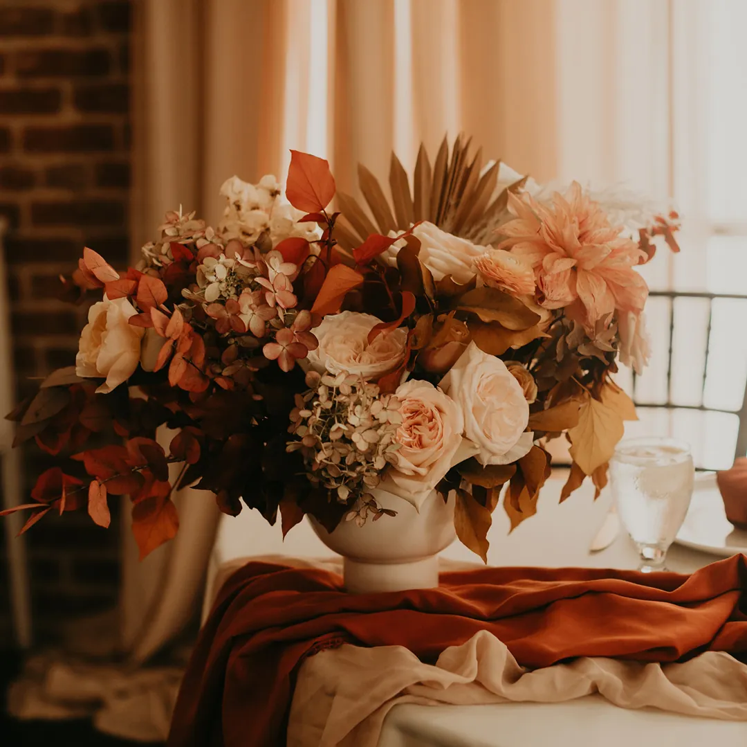 Floral centerpiece with peach and cream flowers