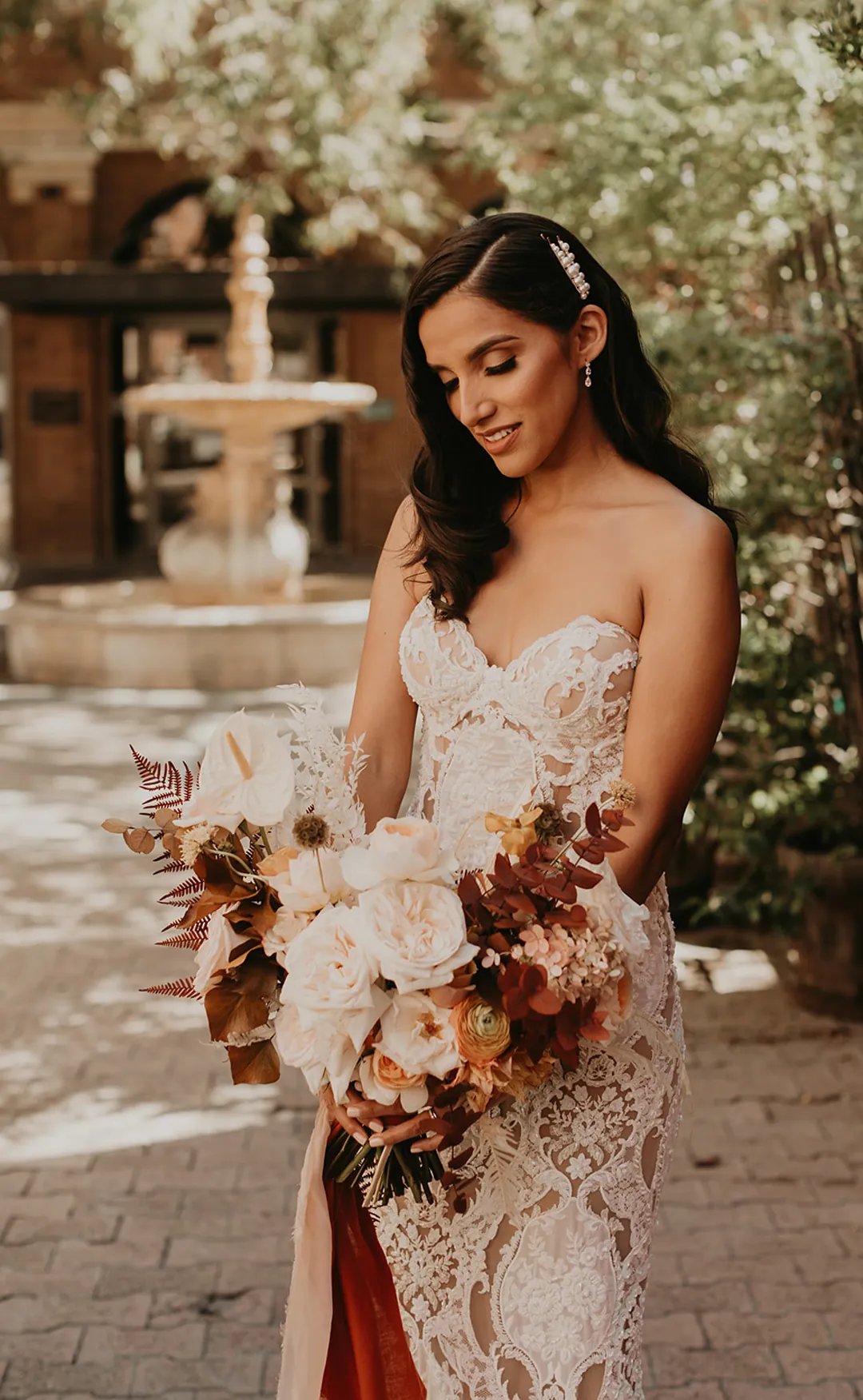 Bride holding a bouquet of cream and rust-colored flowers