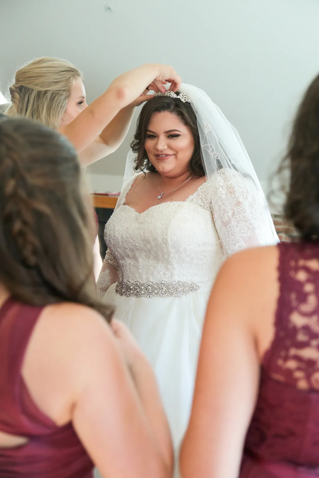 Attendant adjusts a bride's veil.