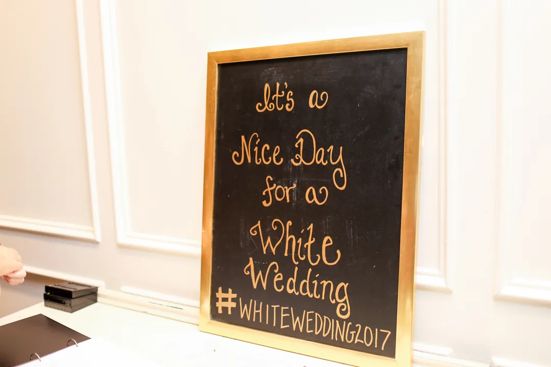 Framed wedding welcome sign on a white table.