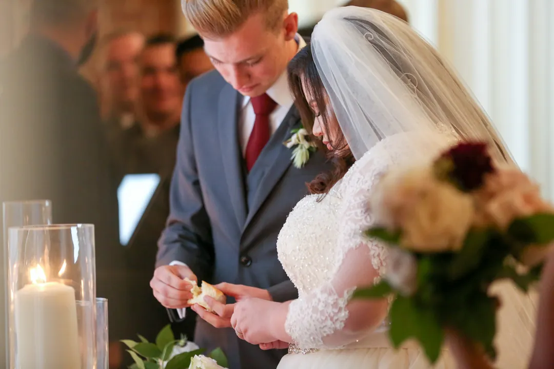 Couple look down together beside tall glass candles.