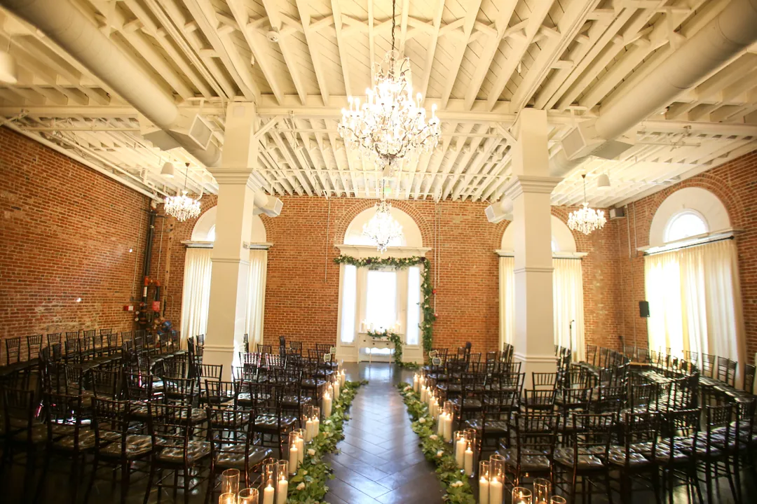 Empty ceremony aisle in a chandelier lit ballroom.